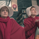 June (Elisabeth Moss) and Janine (Madeline Brewer) watch helplessly as an ambulance passes the market.
